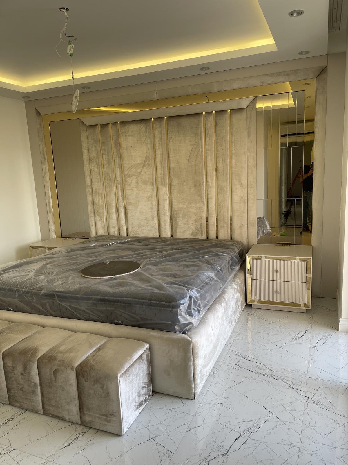 Luxury bedroom with gold-trimmed mirrored wardrobe headwall